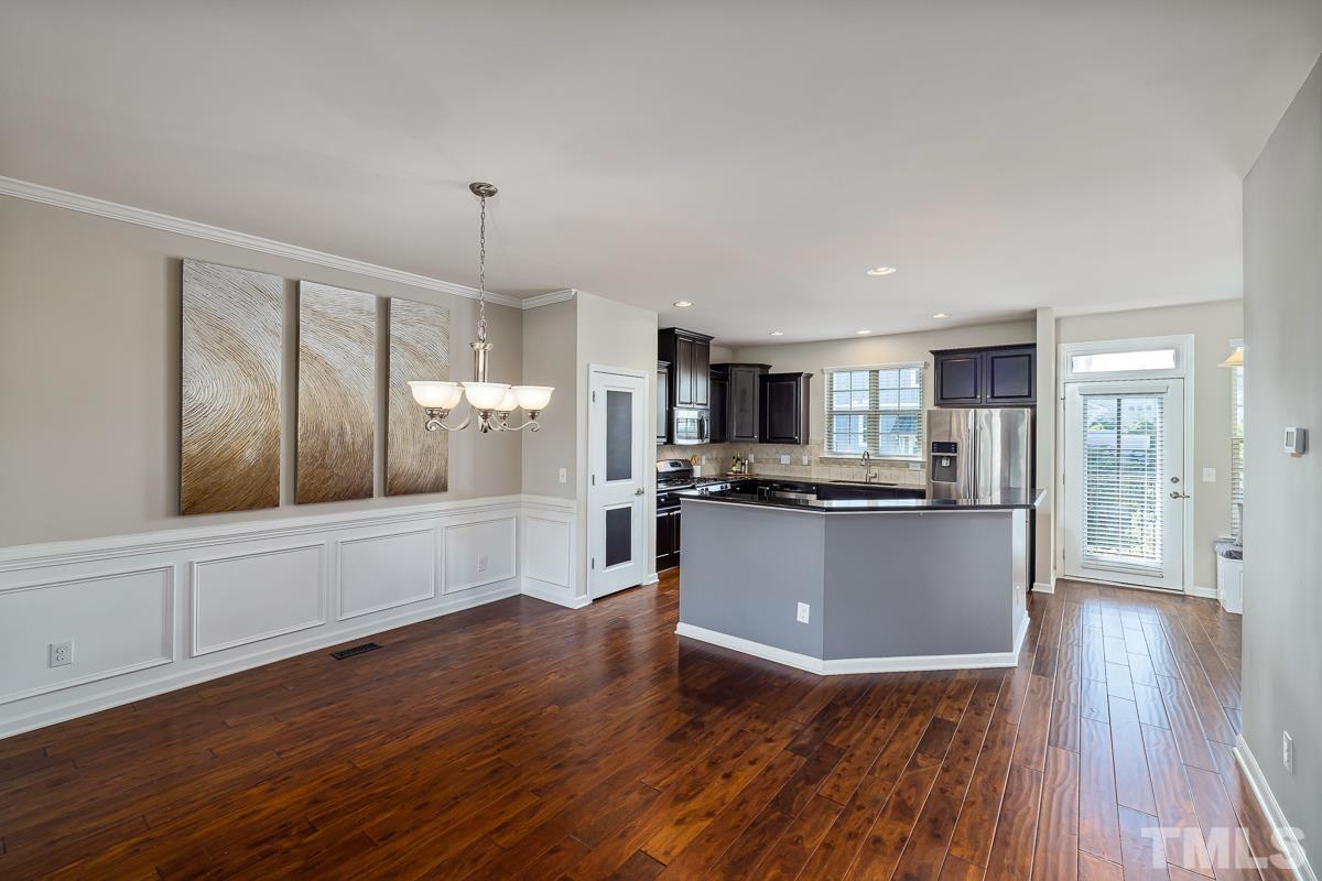 1327 Rembrandt Circle Raleigh, NC 27607 - Photo 14 of 41 a living room with stainless steel appliances kitchen island granite countertop wooden floors and wide window
