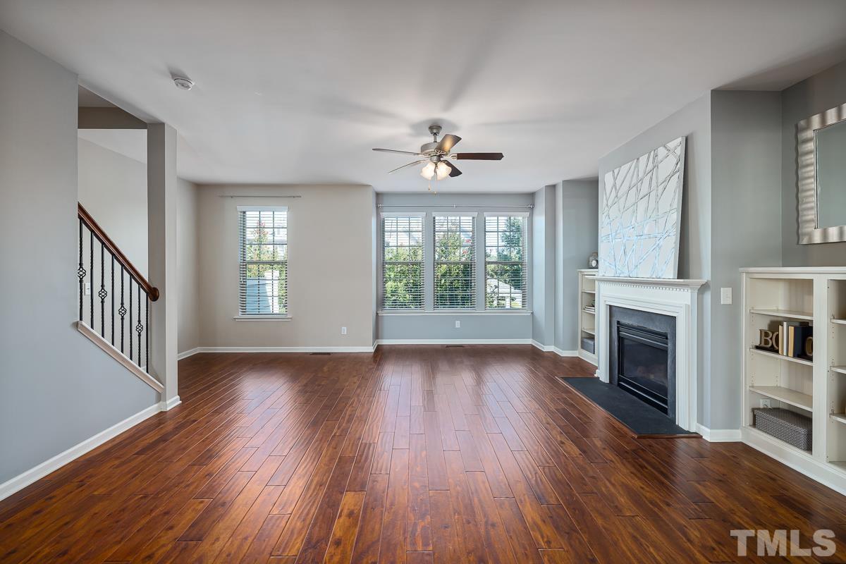 1327 Rembrandt Circle Raleigh, NC 27607 - Photo 18 of 41 an empty room with wooden floor fireplace and windows