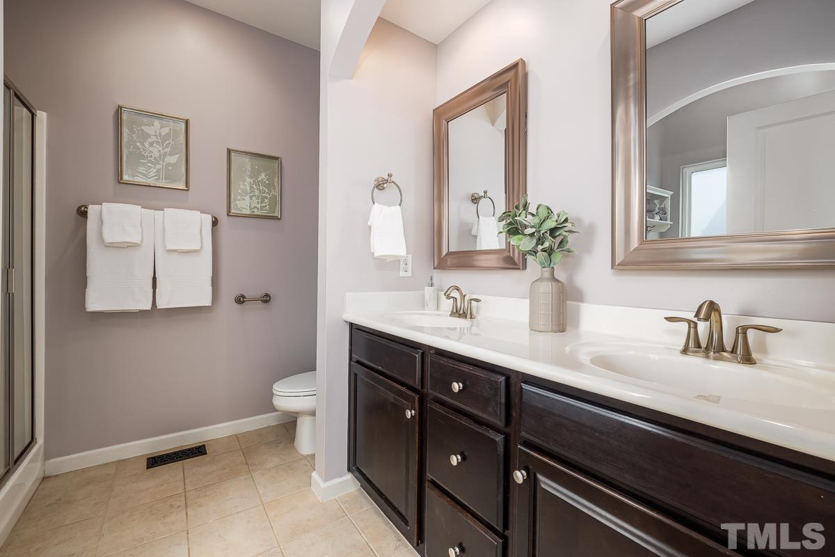 1327 Rembrandt Circle Raleigh, NC 27607 - Photo 26 of 41 a bathroom with a double vanity sink toilet and a mirror