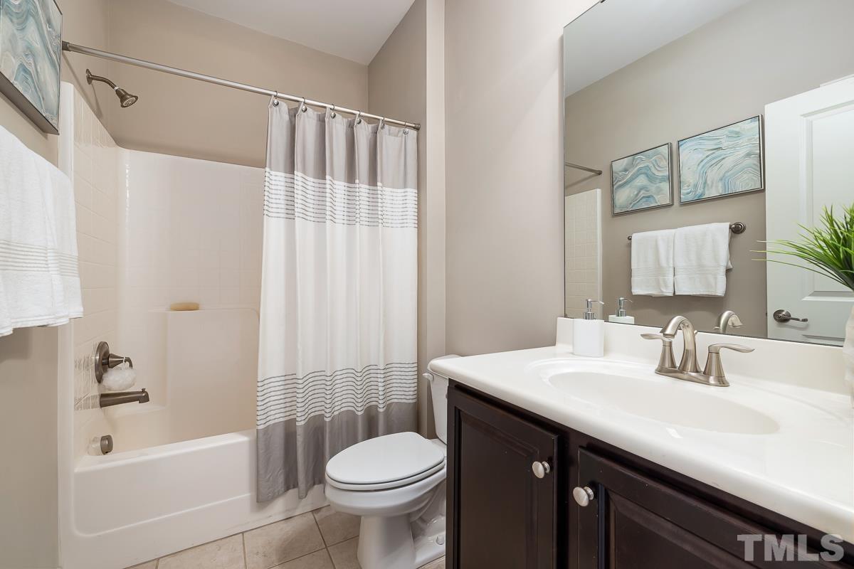 1327 Rembrandt Circle Raleigh, NC 27607 - Photo 34 of 41 a bathroom with a sink a toilet a mirror a bathtub and shower