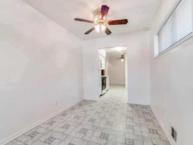 a view of a hallway with a chandelier fan and windows
