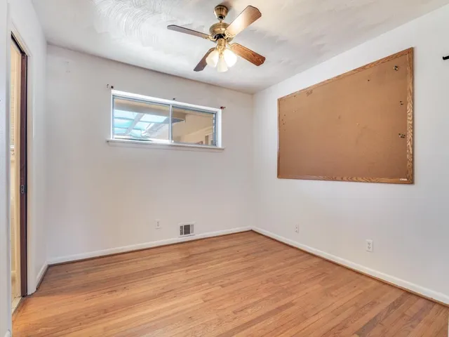 a view of empty room with wooden floor