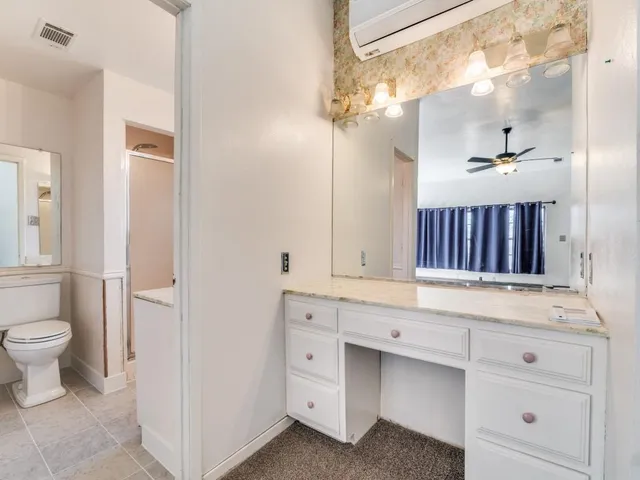 a bathroom with a sink a toilet and a mirror