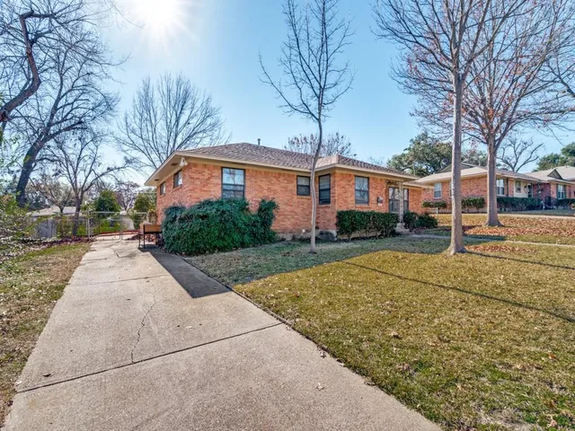 a front view of a house with a yard and trees