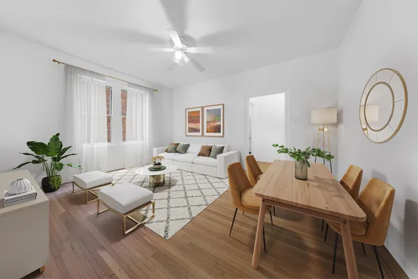 a living room with furniture a chandelier and wooden floor