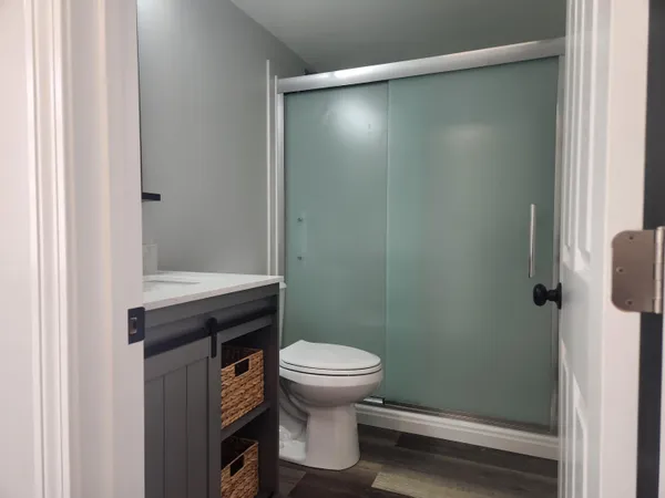 a bathroom with a sink a toilet and shower