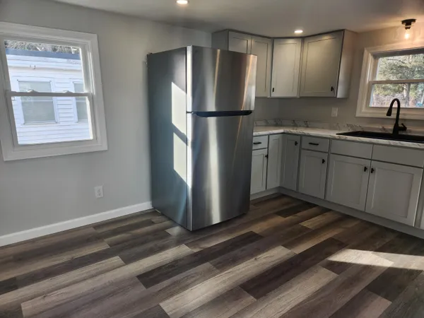 a kitchen with granite countertop a refrigerator and a sink