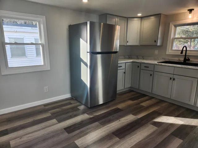 a kitchen with granite countertop a refrigerator and a sink