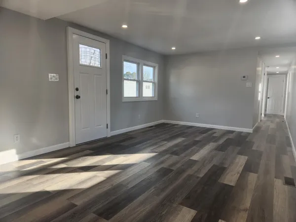 a view of empty room with wooden floor