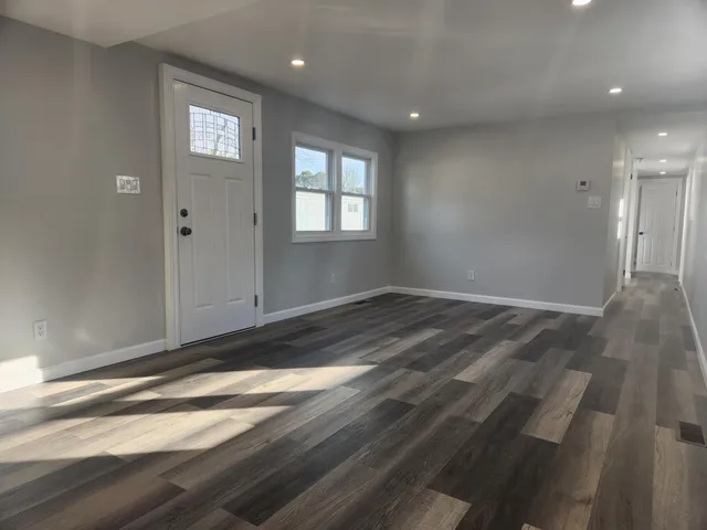 a view of empty room with wooden floor