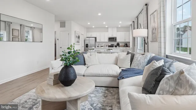 a living room with furniture white walls and a chandelier