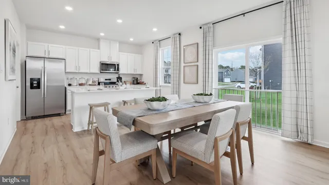 a kitchen with a dining table chairs refrigerator and cabinets