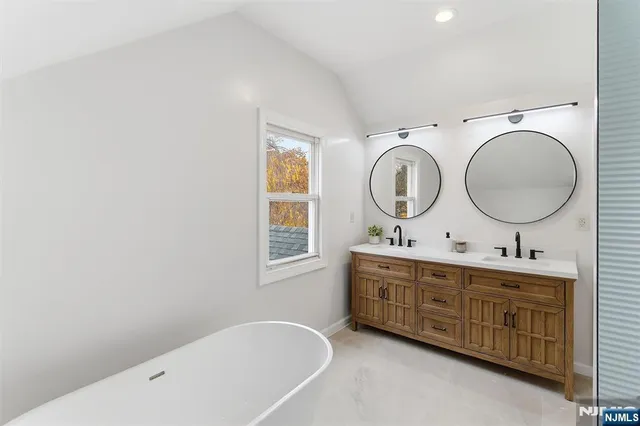 a bathroom with a sink a mirror and a window