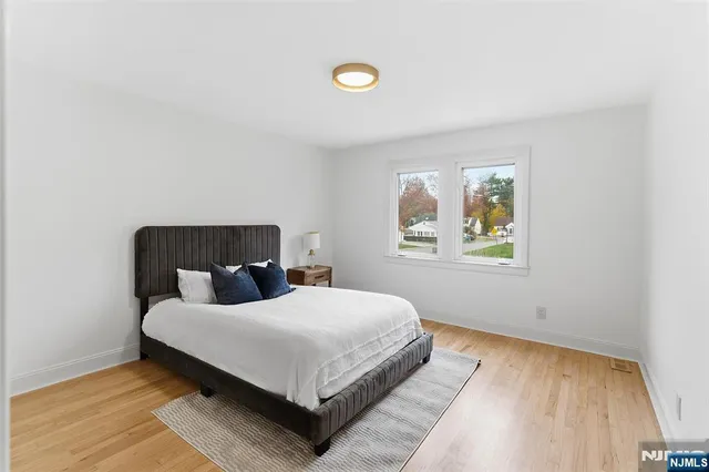 a bedroom with a bed and painting on the wall