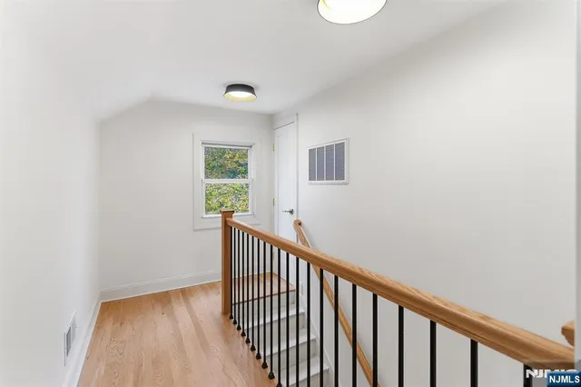 a view of a hallway with wooden floor and a window