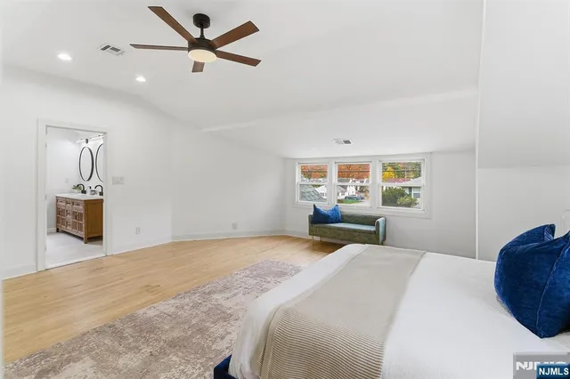 a bedroom with a large bed and a chandelier