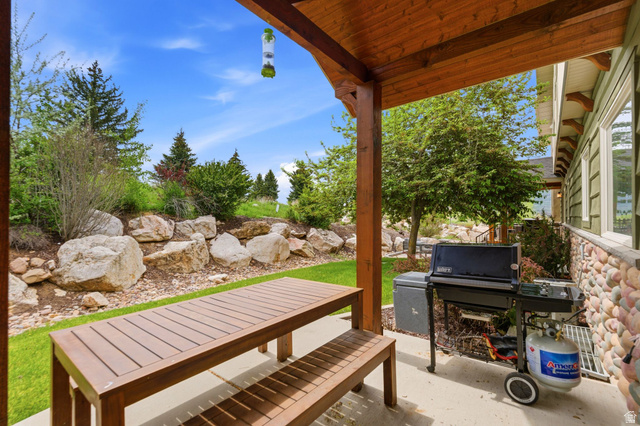 3634 North Huntsman Path, Unit C203 Eden, UT 84310 - Photo 22 of 27 Covered patio with a concrete surface, wooden support beams, and tongue-and-groove ceiling