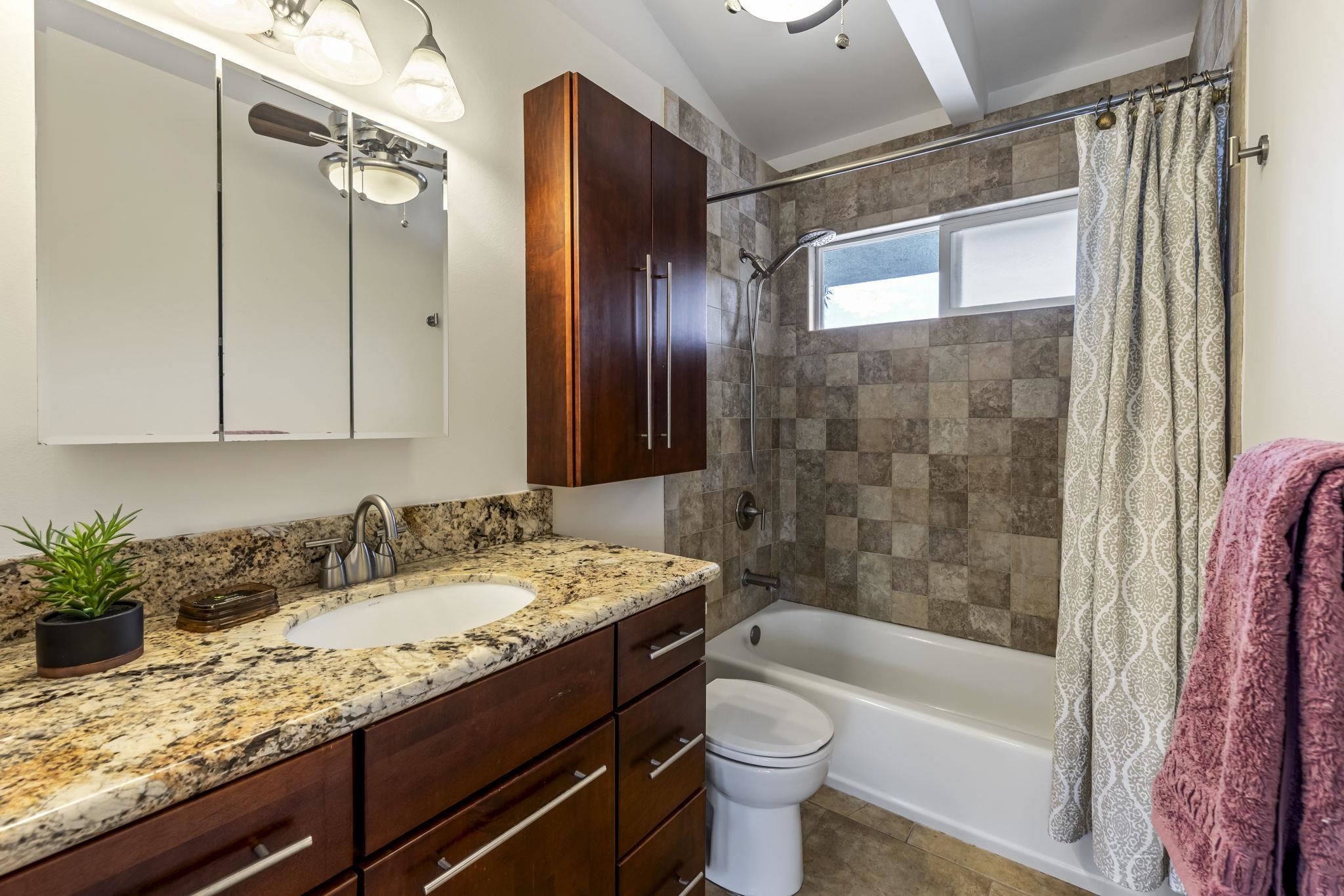 2670 Kanakanui Road Kihei, HI 96753 - Photo 19 of 41 a bathroom with a granite countertop sink toilet and shower