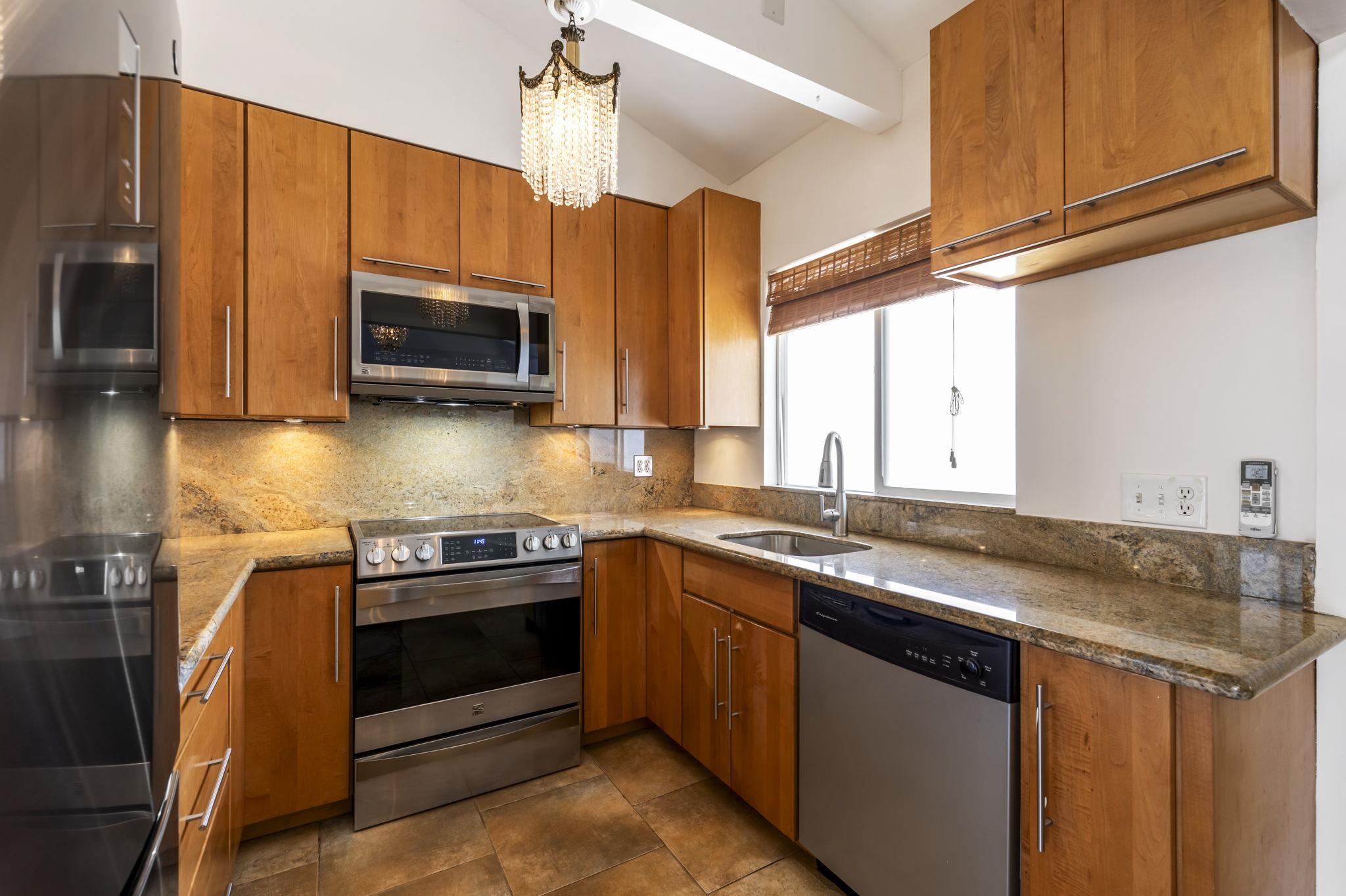 2670 Kanakanui Road Kihei, HI 96753 - Photo 9 of 41 a kitchen with stainless steel appliances granite countertop a stove a sink and a microwave