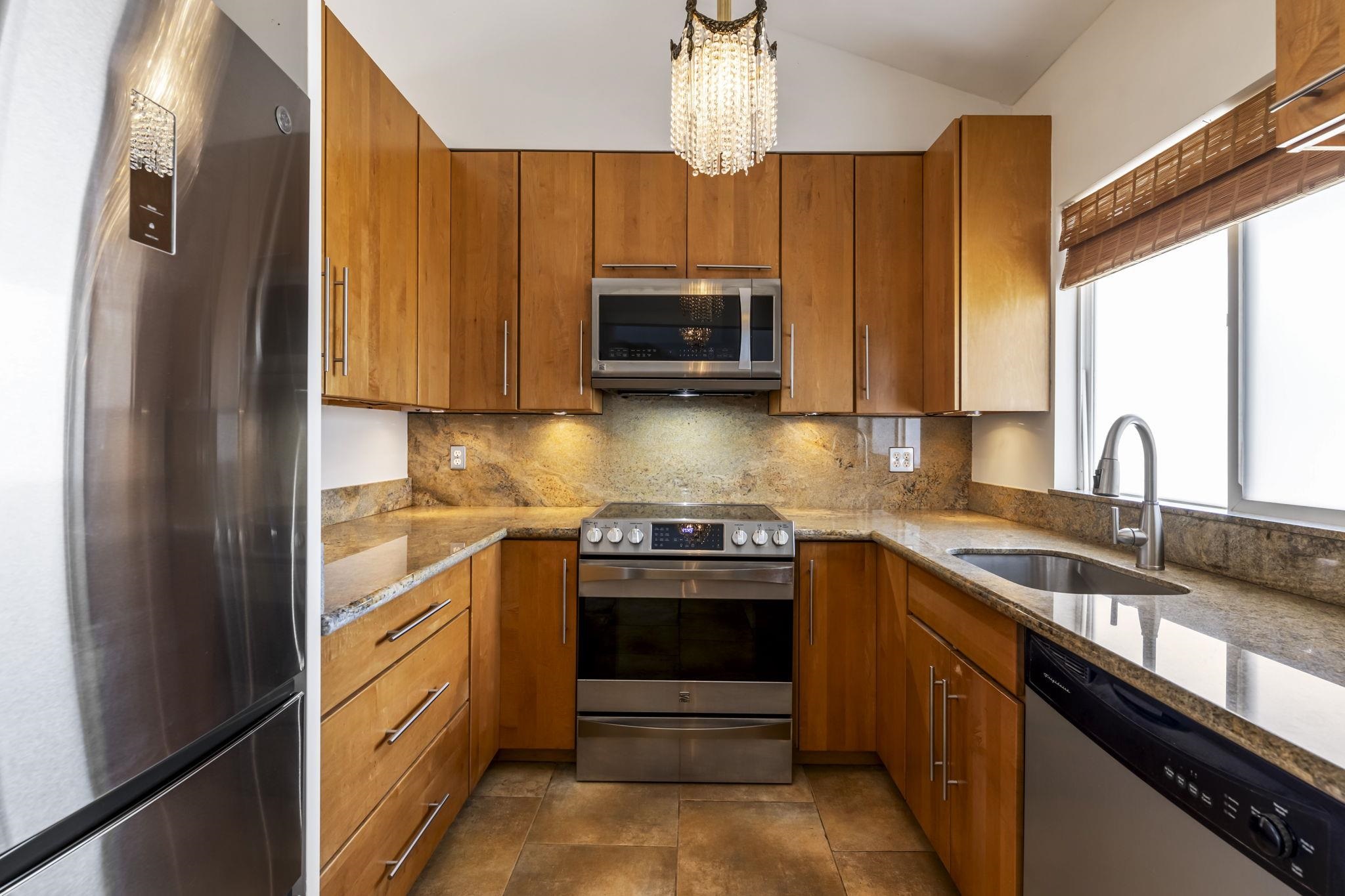 2670 Kanakanui Road Kihei, HI 96753 - Photo 10 of 41 a kitchen with stainless steel appliances granite countertop a stove a sink and a microwave