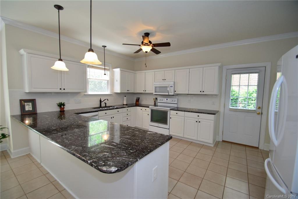 229 Kimberly Road Davidson, NC 28036 - Photo 5 of 23 a kitchen with stainless steel appliances granite countertop a sink a counter top space cabinets and a window