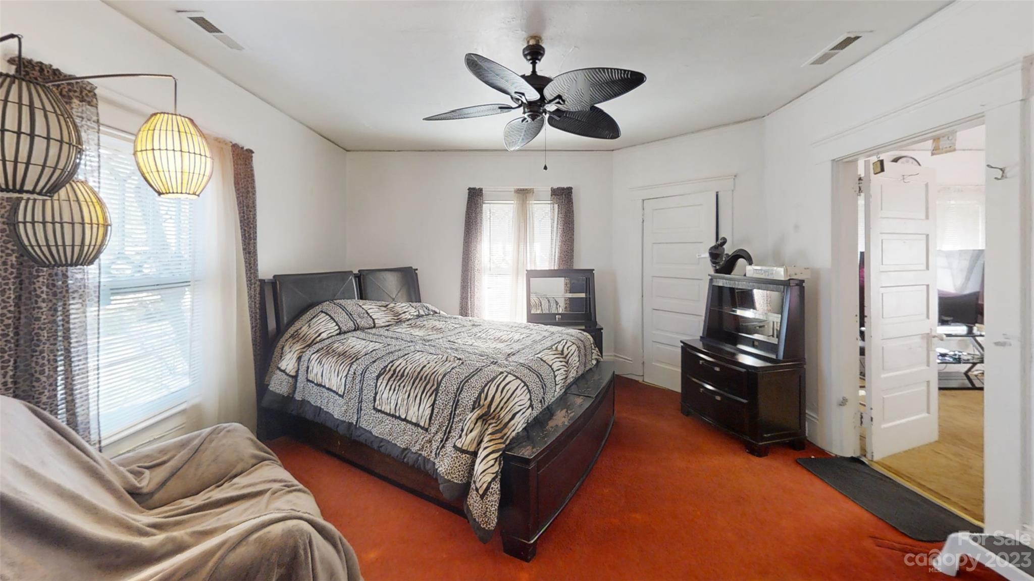 182 Flint Street Asheville, NC 28801 - Photo 17 of 22 a spacious bedroom with a bed and a chandelier