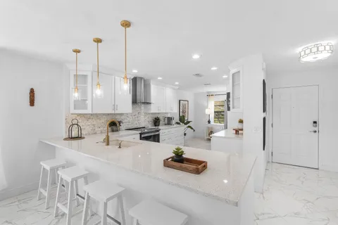a kitchen with kitchen island granite countertop a sink counter top space appliances and cabinets