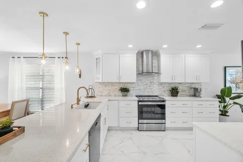 a kitchen with white cabinets and white appliances