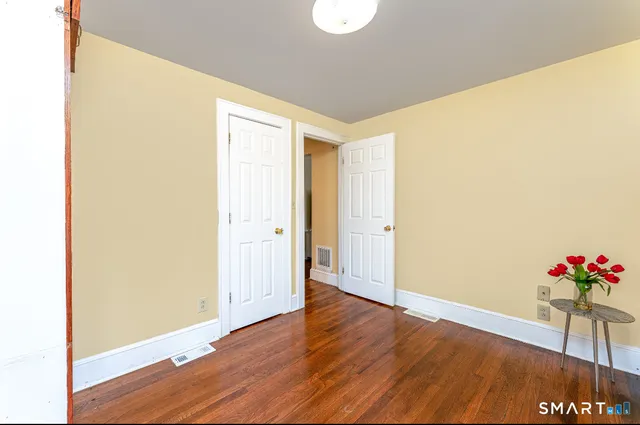 a view of an empty room with wooden floor