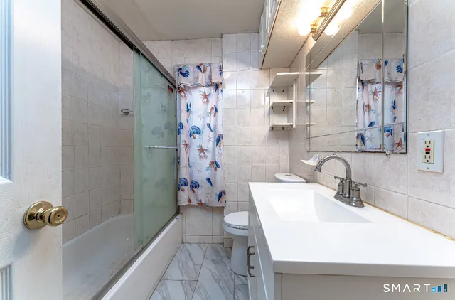 a bathroom with a sink a mirror a bathtub and shower