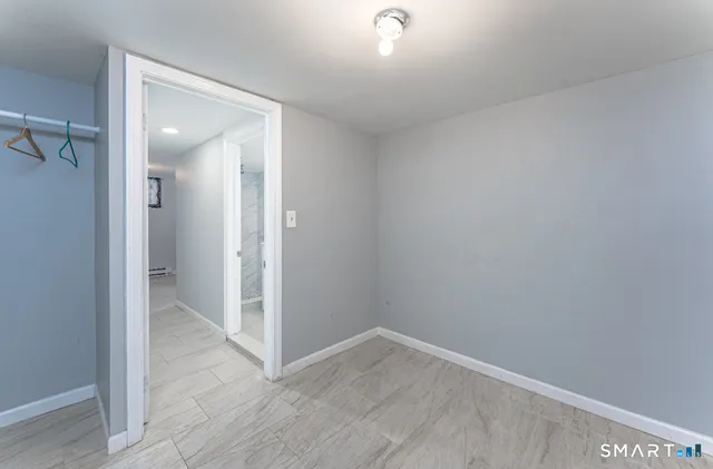 an empty room with wooden floor and mirror