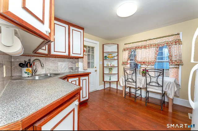a kitchen with stainless steel appliances granite countertop wooden cabinets a dining table and chairs
