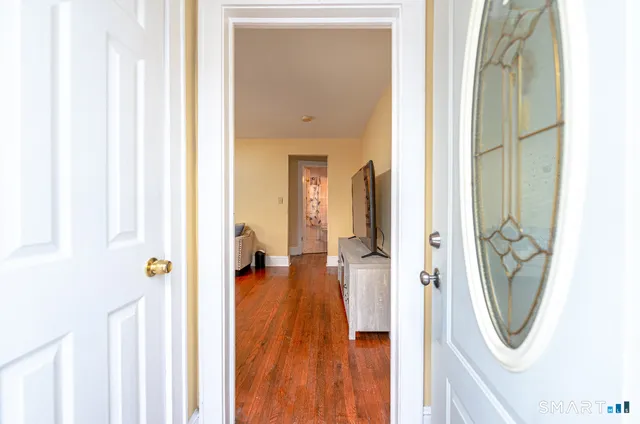 a view of a hallway with wooden floor a glass door