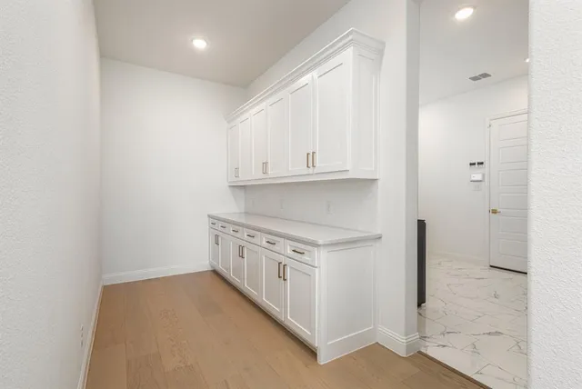 a large white kitchen with cabinets and stainless steel appliances