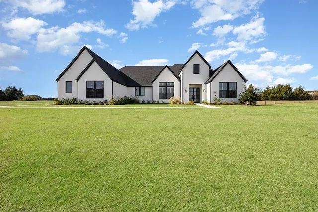 a front view of a house with yard and green space