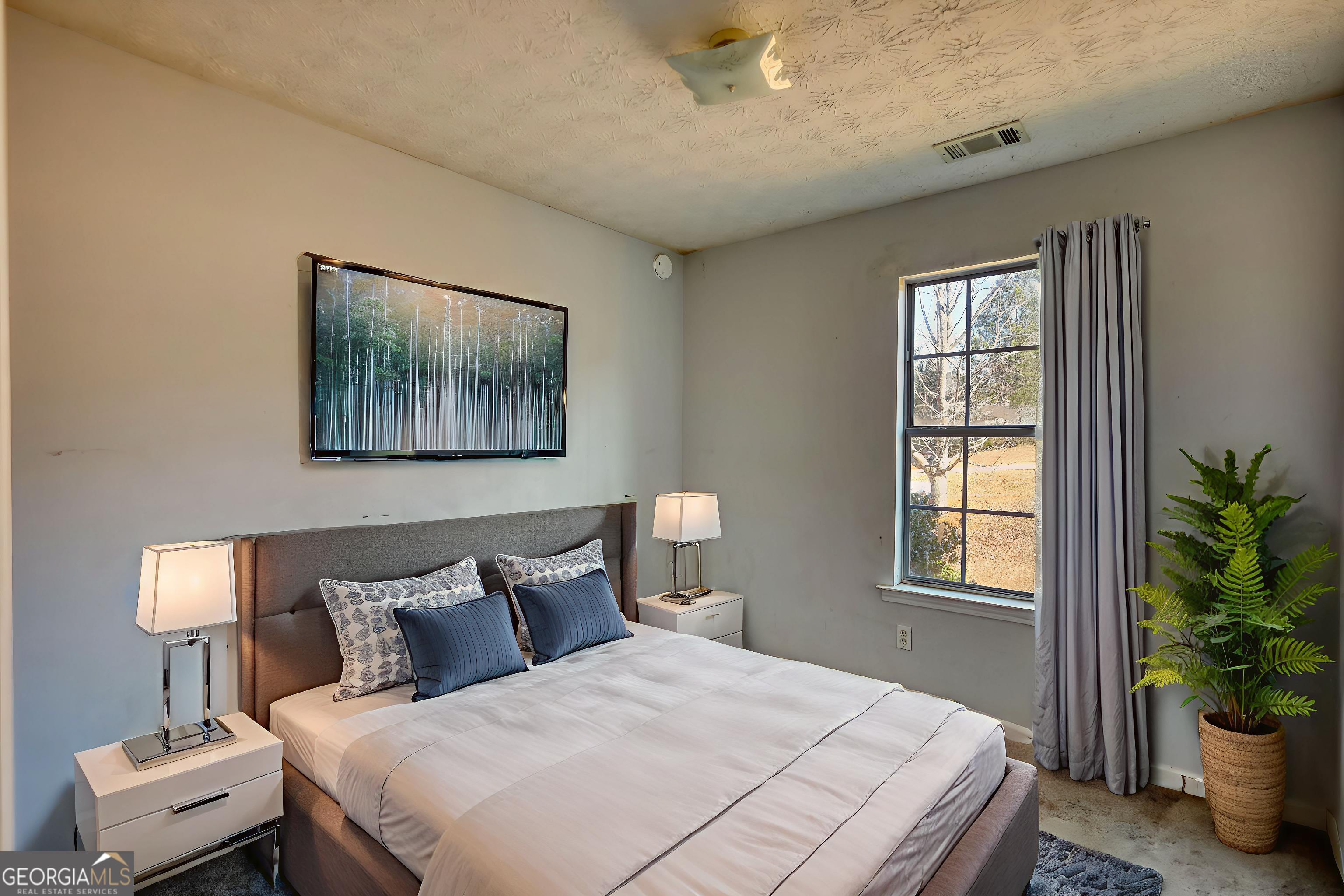 253 Nancy Street Monticello, GA 31064 - Photo 15 of 34 a bedroom with a bed and a potted plant