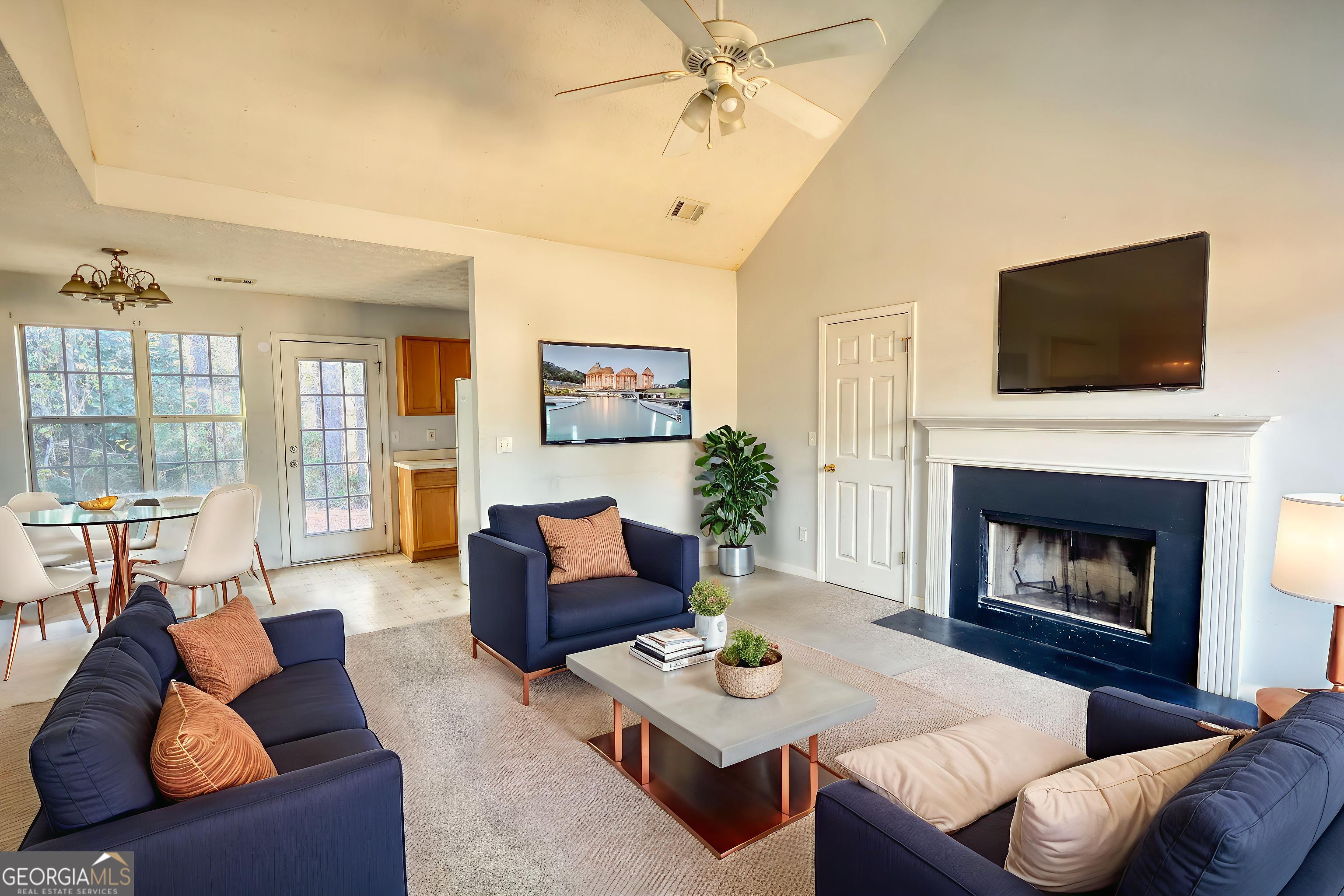253 Nancy Street Monticello, GA 31064 - Photo 3 of 34 a living room with furniture a flat screen tv and a fireplace