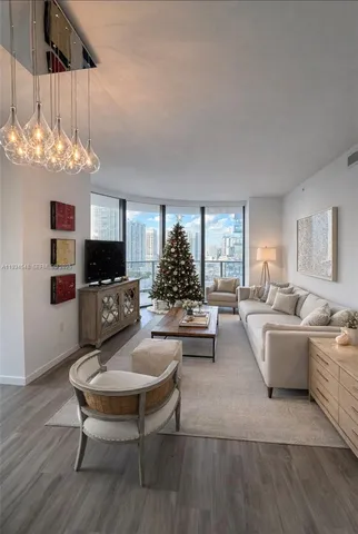a living room with furniture a chandelier and a flat screen tv