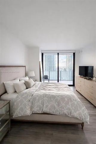 a bedroom with a large bed and a flat screen tv