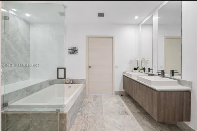 a bathroom with a tub sink and mirror