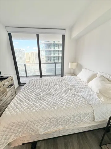 a large bed sitting in a bedroom next to a window