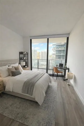 a bedroom with a bed and a large window