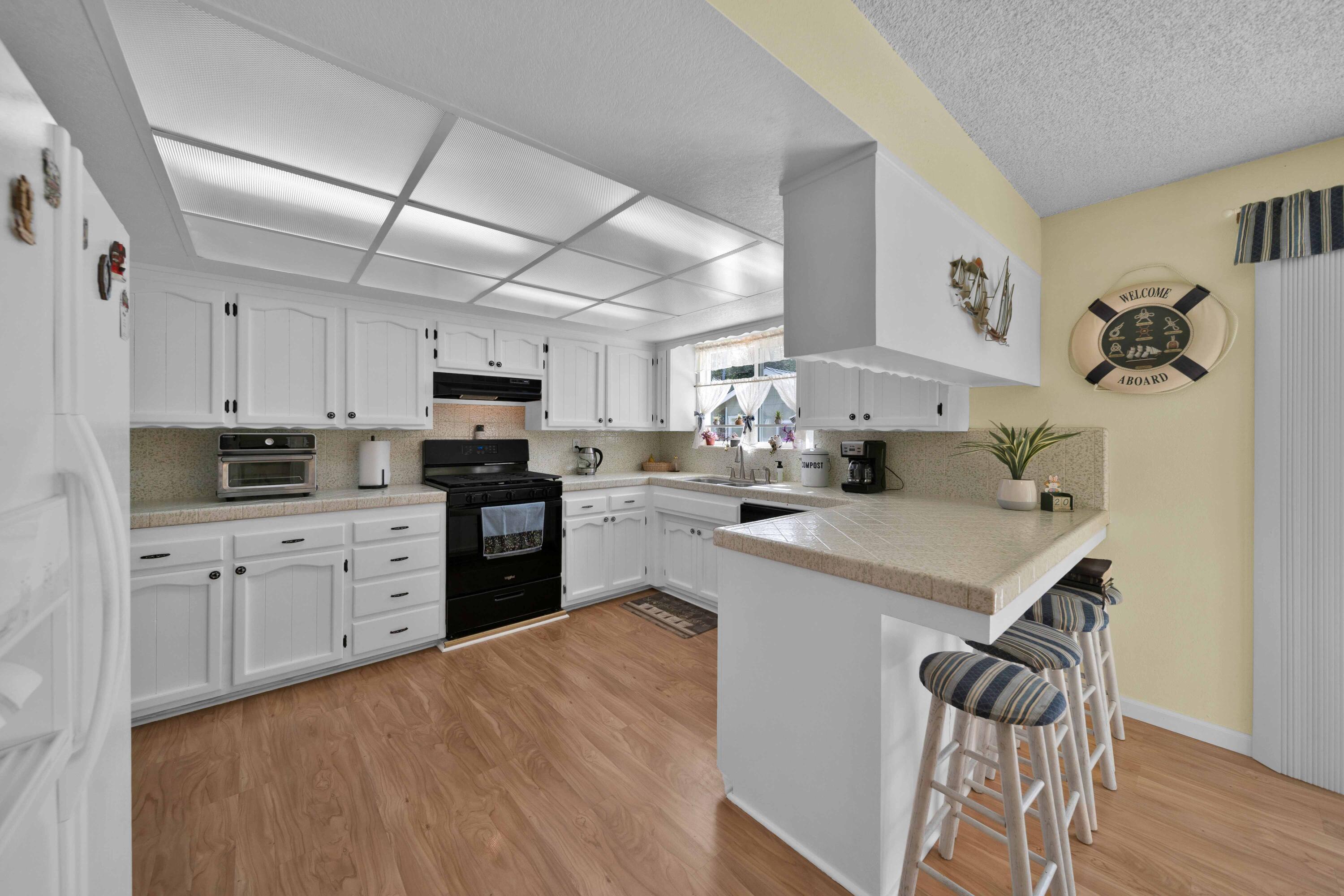 2195 Rancho Road Redding, CA 96002 - Photo 15 of 47 a kitchen with a sink a stove a refrigerator and white cabinets