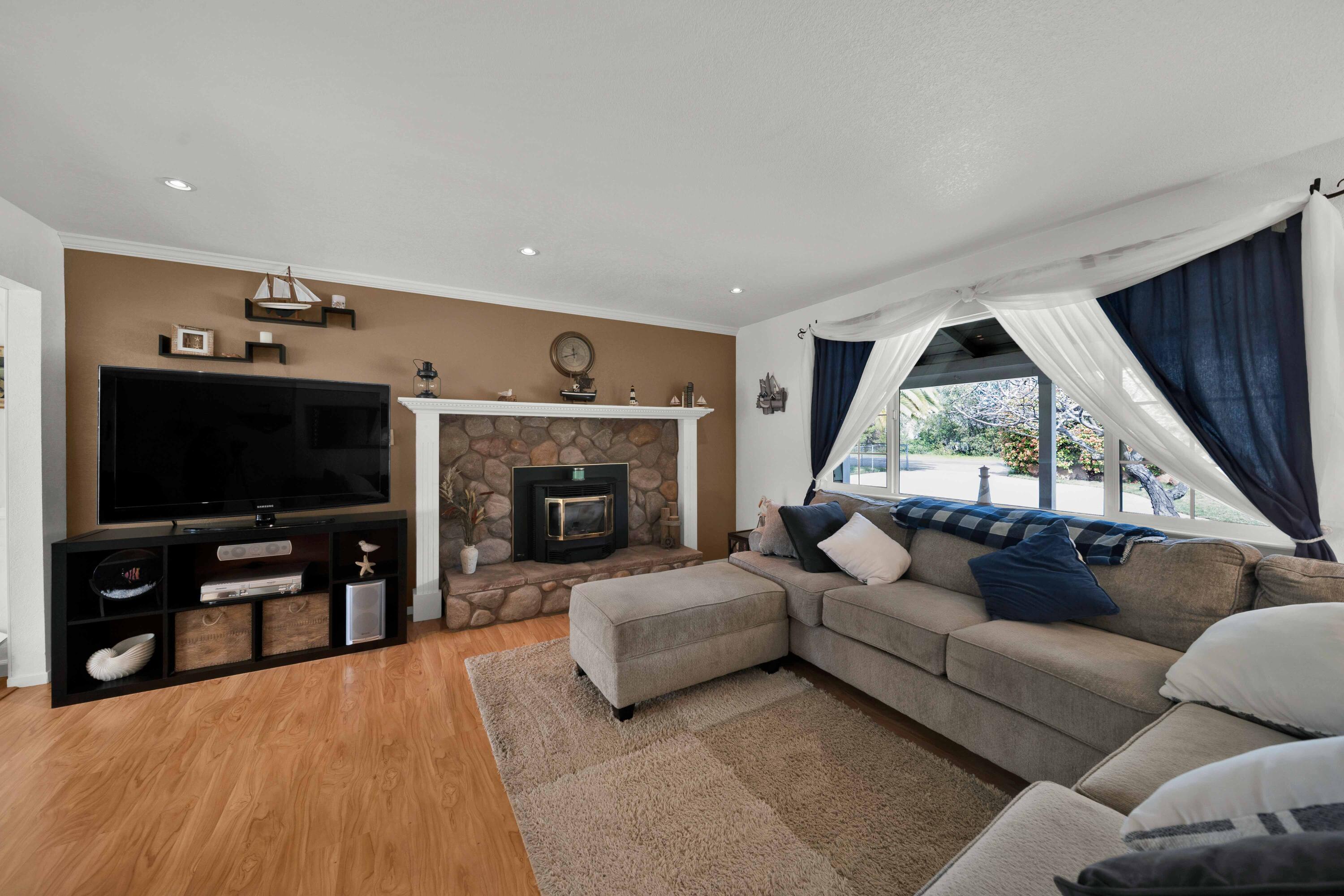 2195 Rancho Road Redding, CA 96002 - Photo 8 of 47 a living room with furniture a flat screen tv and a fireplace