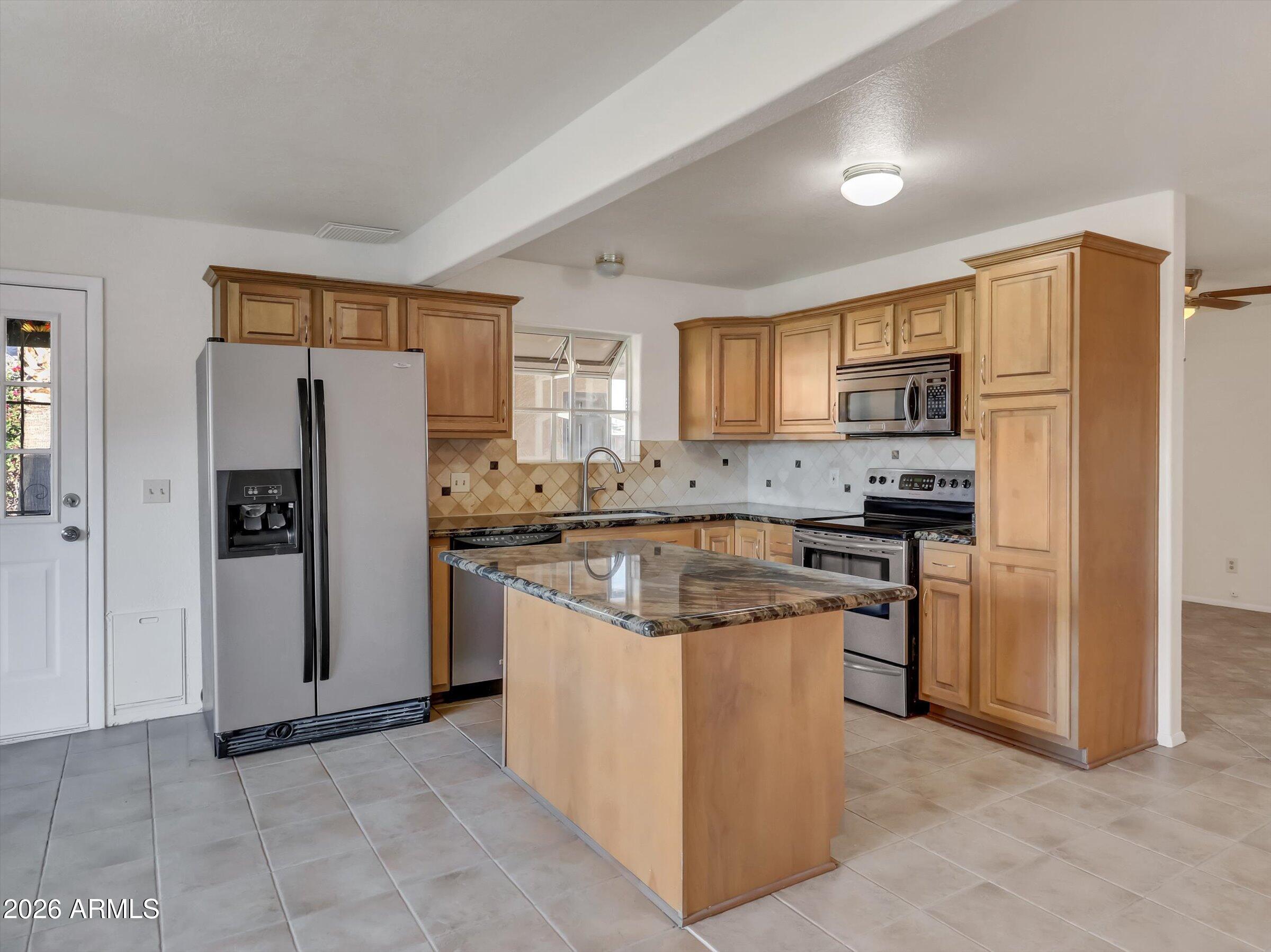 1705 East Grandview Road Phoenix, AZ 85022 - Photo 4 of 19 a kitchen with stainless steel appliances granite countertop a refrigerator stove and a sink