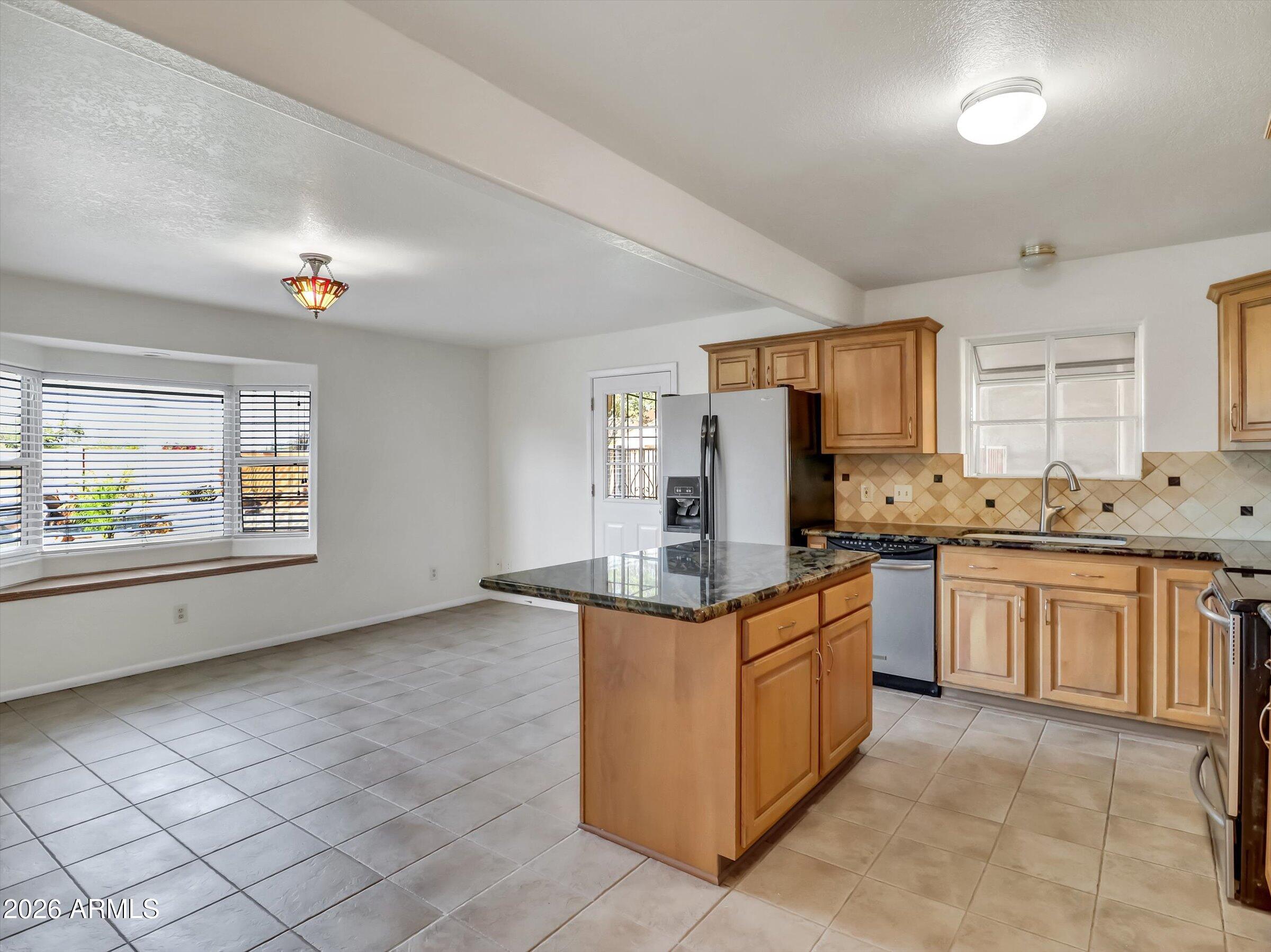 1705 East Grandview Road Phoenix, AZ 85022 - Photo 5 of 19 a kitchen with stainless steel appliances granite countertop a stove a sink and a refrigerator