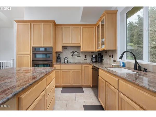 a kitchen with a sink a counter top space cabinets and stainless steel appliances