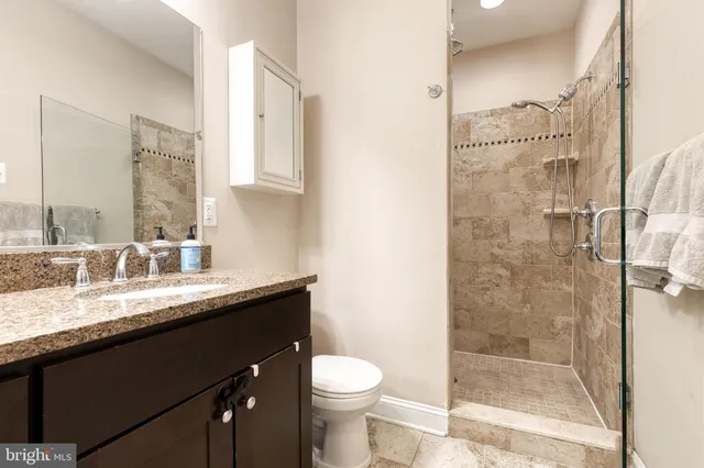 a bathroom with a granite countertop sink toilet and shower