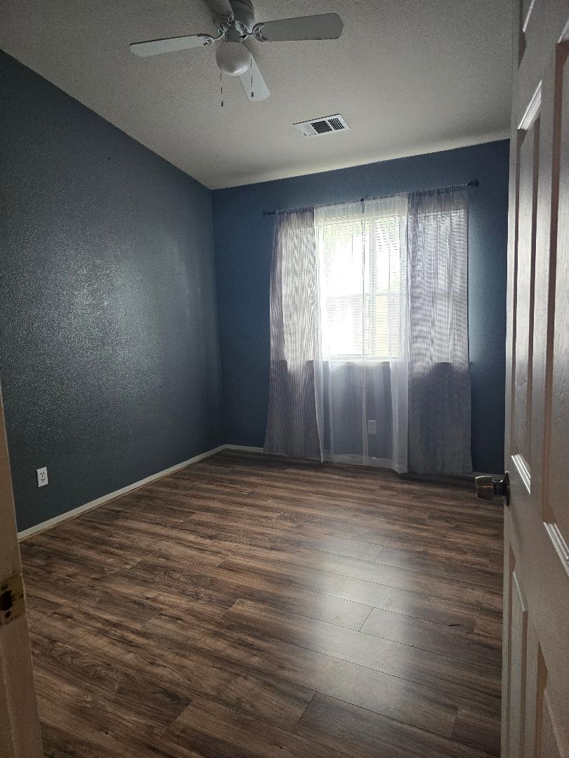 29124 Rio Verde Drive Gustine, CA 95322 - Photo 11 of 19 an empty room with wooden floor and windows