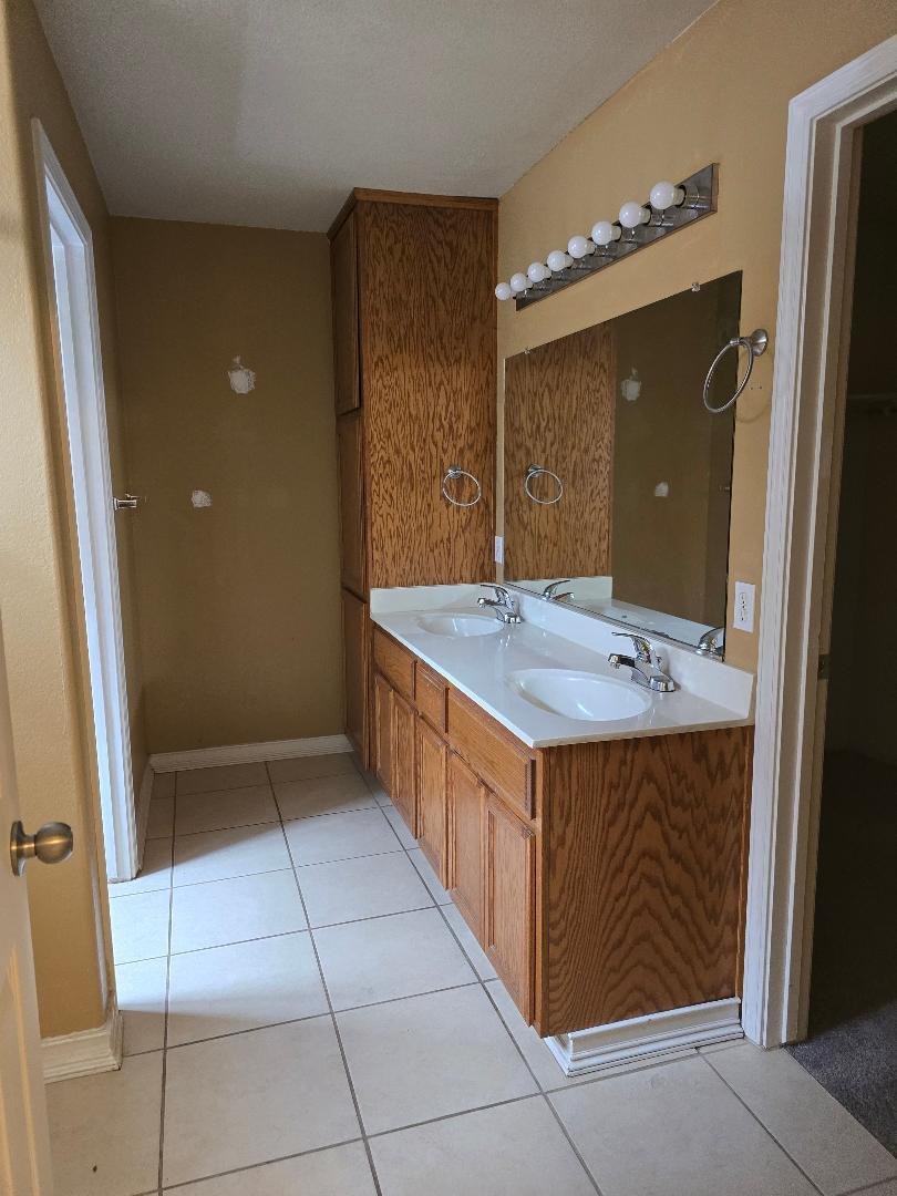 29124 Rio Verde Drive Gustine, CA 95322 - Photo 13 of 19 a bathroom with a granite countertop sink and a mirror